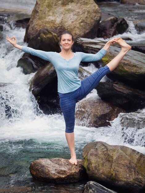 Foto mujer haciendo ashtanga vinyasa yoga asana al aire libre en la cascada