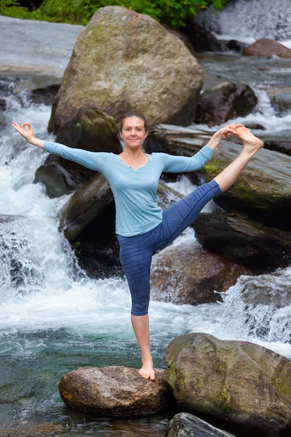 Mujer haciendo Ashtanga Vinyasa Yoga asana al aire libre en cascada