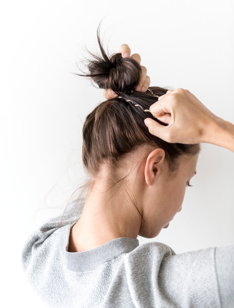 Mujer haciendo bollo de pelo