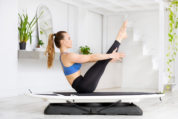 Mujer haciendo un bote de yoga surf piernas rectas plantean