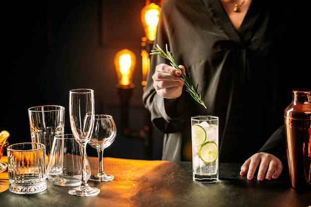 Mujer haciendo cóctel de gin tonic fresco con limón