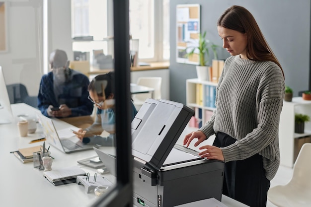 Foto mujer haciendo una copia de un documento en el trabajo