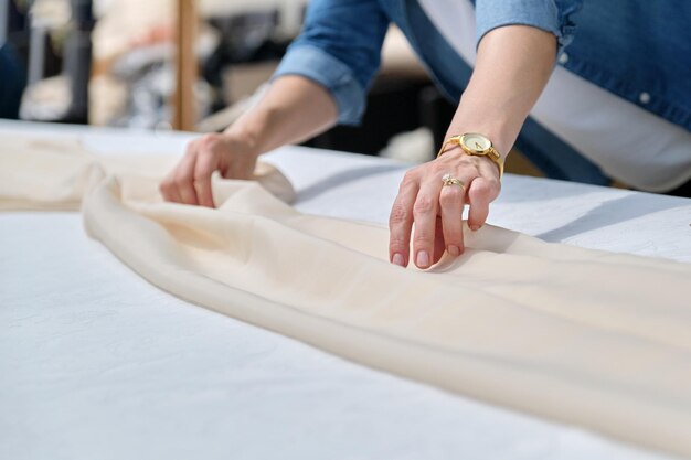 Mujer haciendo decoración navideña con mantel en la mesa