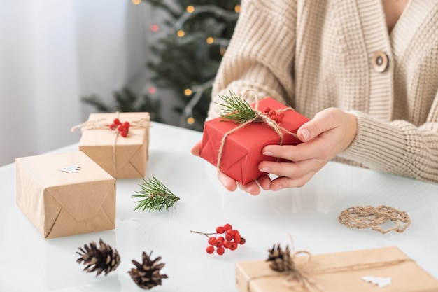 Mujer haciendo decoración navideña en la mesa