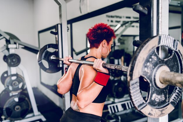 Mujer haciendo ejercicio con barra en el gimnasio