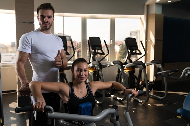 Mujer haciendo ejercicio de espalda con su entrenador personal