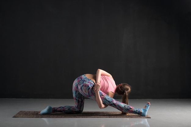 Mujer haciendo ejercicio de estiramiento Ardha Hanumanasana o Half Monkey God Pose