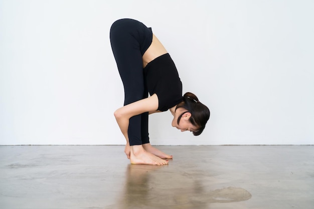 Una mujer haciendo un ejercicio de flexión hacia adelante en el interior