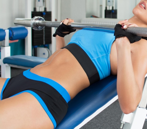 Mujer haciendo ejercicio en el gimnasio levantando pesas ligeras Ajuste psicológico Nutrición deportiva