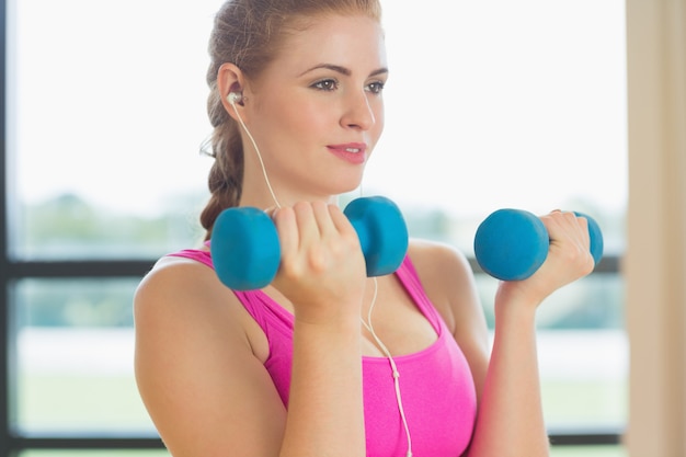 Mujer haciendo ejercicio con pesas en el gimnasio