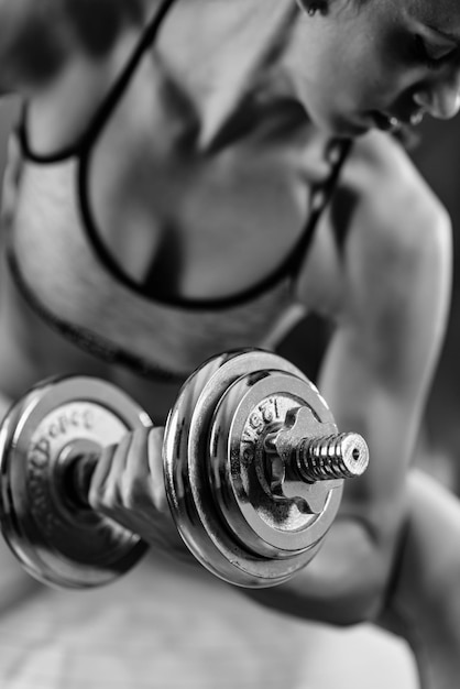 Mujer haciendo ejercicio con pesas en el gimnasio.