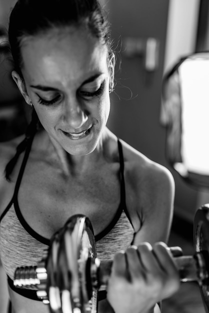 Mujer haciendo ejercicio con pesas en el gimnasio.