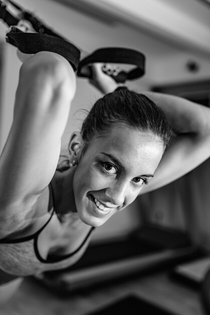 Mujer haciendo ejercicio en TRX en el gimnasio