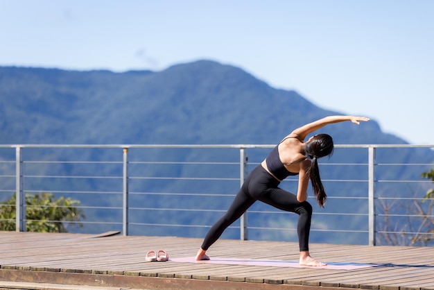 Mujer haciendo ejercicio de yoga en la montaña