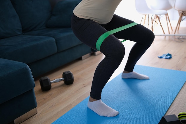 Mujer haciendo ejercicios con cinta elástica en las piernas