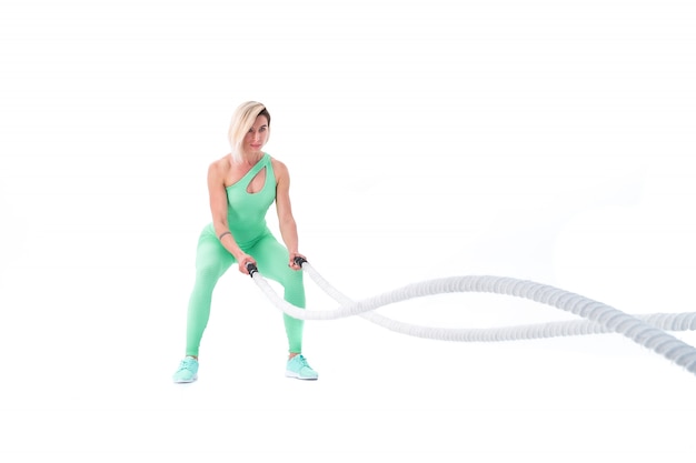 Mujer haciendo ejercicios con cuerda de batalla en blanco