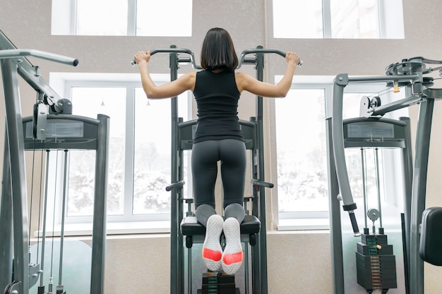 Mujer haciendo ejercicios para la espalda en una máquina de fitness