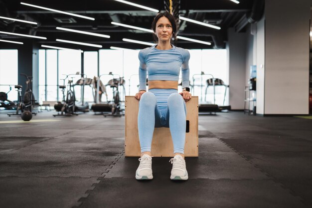 Mujer haciendo ejercicios de tríceps en caja de salto crossfit de madera