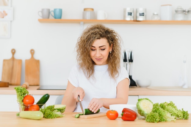 Mujer haciendo ensalada en la cocina.