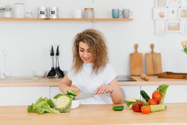 Mujer haciendo ensalada en la cocina.