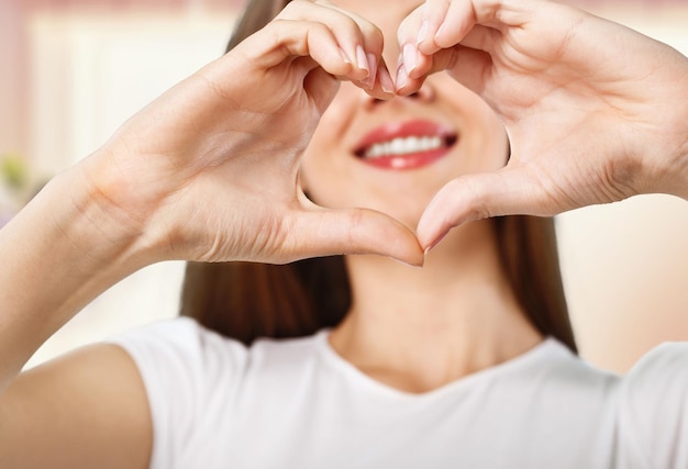 Mujer haciendo una forma de corazón con sus manos - aislado sobre blanco