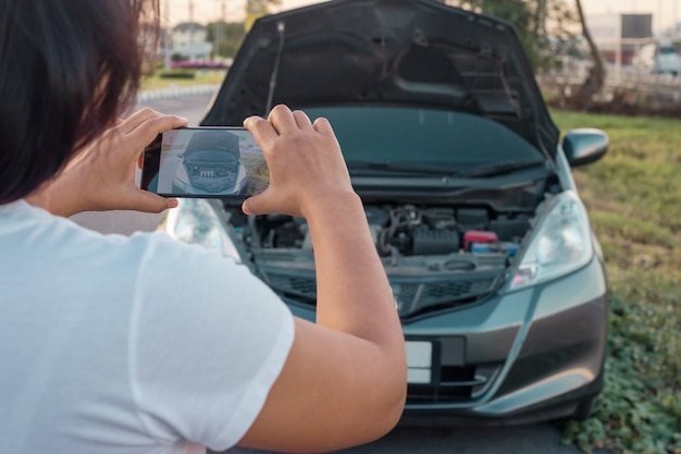 mujer haciendo foto al motor del coche