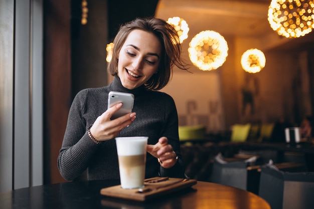 Mujer haciendo fotos de un café en un café