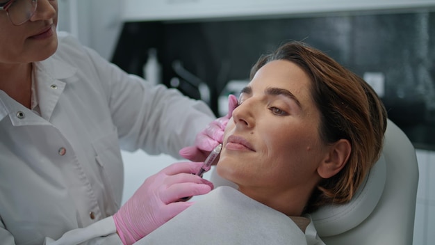 Mujer haciendo inyección de belleza en la clínica de cosmetología cerca del rejuvenecimiento de la piel