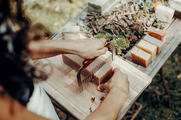 Foto la mujer está haciendo jabones naturales artesanales sobre una mesa de madera antigua