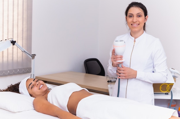 Foto mujer haciendo lipocavitación en el paciente.