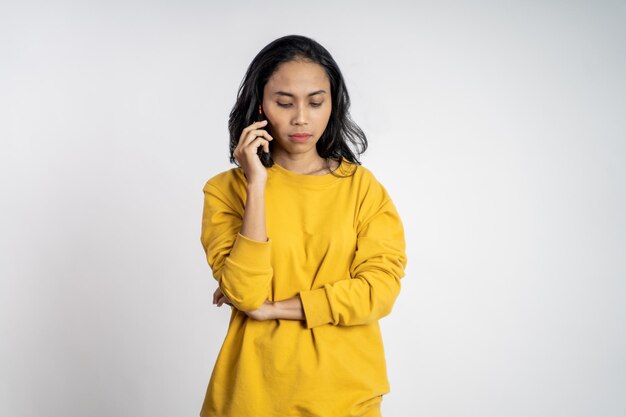 Mujer haciendo una llamada usando un teléfono celular en un fondo aislado