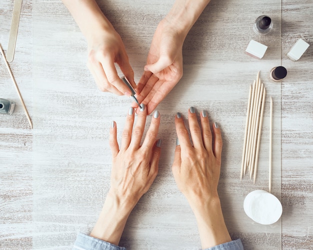 Mujer haciendo manicura a un cliente en interiores