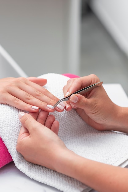 Mujer haciendo manicura a un cliente