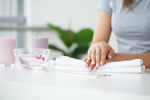 Mujer haciendo manicura cuando descansa en casa