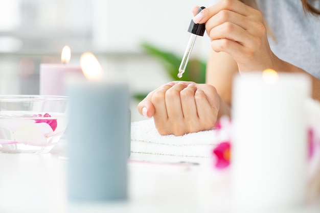 Mujer haciendo manicura cuando descansa en casa