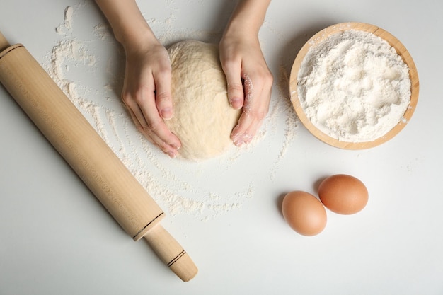 Mujer haciendo masa en la mesa de la cocina