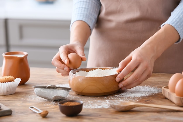 Mujer haciendo masa en la mesa de la cocina