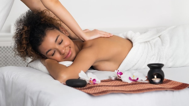 Mujer haciendo masaje de espalda con aroma en un salón de spa