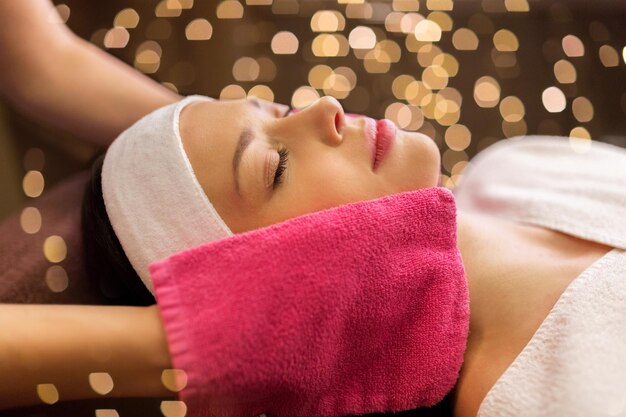 mujer haciendo masaje facial con guantes de terry en el spa