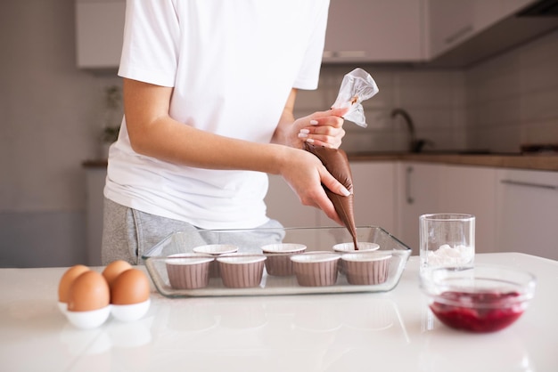 Mujer haciendo muffins de chocolate en casa