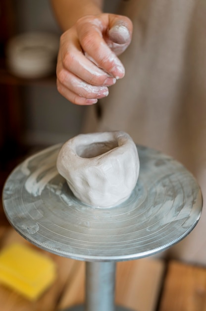 Foto mujer haciendo una olla de barro en su taller