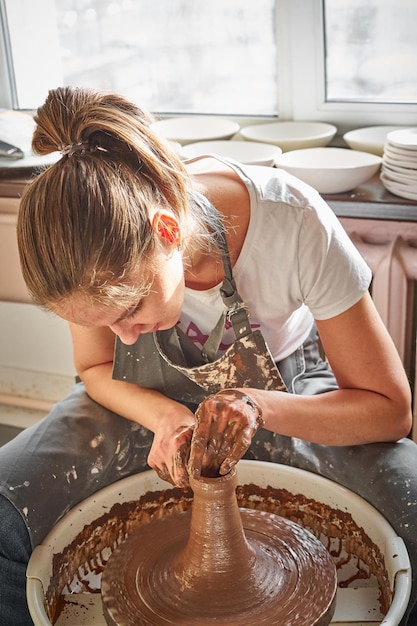 Mujer haciendo olla en el taller