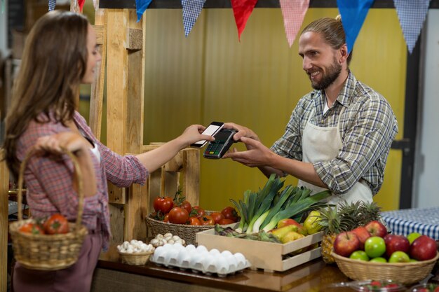 Mujer haciendo un pago mediante tecnología NFC