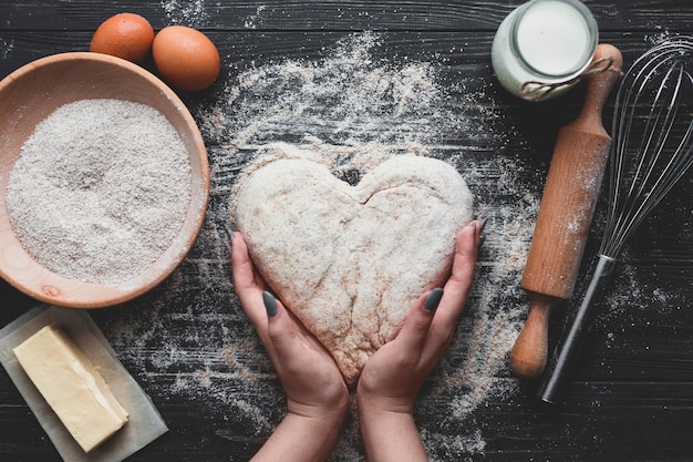 Foto mujer haciendo pan en forma de corazón