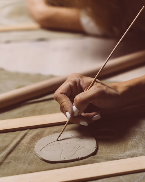 Mujer haciendo patrón en placa de cerámica, dibujo. Concepto creativo de hobby. Gana dinero extra