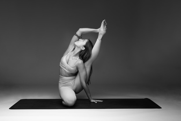 Mujer haciendo una pose de yoga foto en blanco y negro