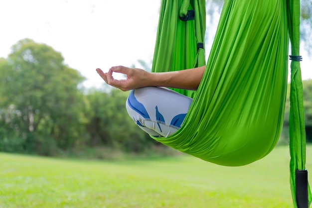 Mujer haciendo postura de meditación en una hamaca de yoga antigravedad Concepto de yoga aéreo Copiar ritmo