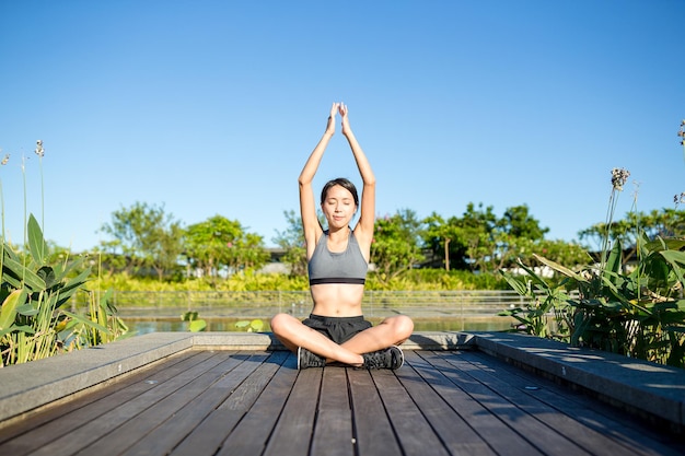 Mujer haciendo postura de yoga en el parque