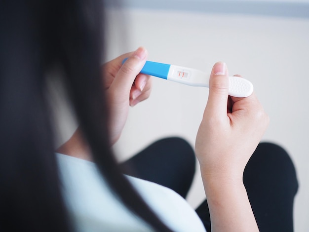 Mujer haciendo una prueba de embarazo en casa