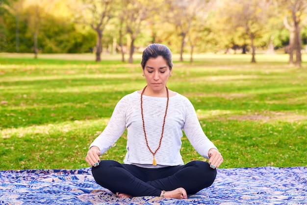 Mujer haciendo reiki y pose de yoga en una pose de chakra del parque